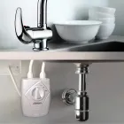 Aquecedor de água Lorenzetti branco sob pia com torneira e louças.