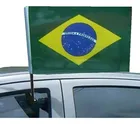 Bandeira do Brasil pequena verde e amarela fixada na janela de um carro.