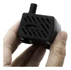 Mãos segurando bomba submersa preta compacta com grade e bico.