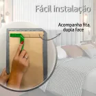 Mão aplicando fita dupla face verde no verso de um módulo de cabeceira queen