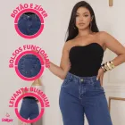 Mulher vestindo calça jeans azul escura com botão, zíper e bolsos traseiros