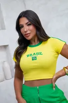 Mulher usando camiseta Baby Look Brasil amarela bordada com BRASIL verde e bandeira.