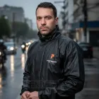 Homem veste capa chuva motoqueiro preta Pioneira em rua chuvosa.