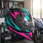 Capacete Moto Feminino preto com grafismos rosa e azul-turquesa, viseira transparente.