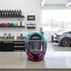 Capacete Moto Feminino preto, azul-turquesa e rosa choque com design esportivo e viseira escura.