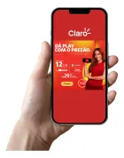 Mão segura smartphone com tela exibindo anúncio Claro vermelho de 12GB e mulher.