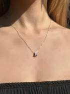 Colar Nossa Senhora Aparecida de prata com pingente escuro triangular no pescoço