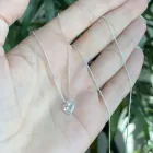 Colar Ponto de Luz prata com pingente coração brilhante na mão