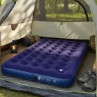 Colchão inflável azul escuro com gomos dentro de barraca de camping