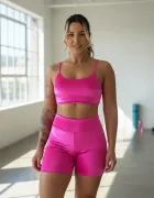 Conjunto fitness rosa choque: mulher com top, shorts e tatuagem no braço