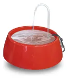 Fonte bebedouro vermelha com água fluindo de um tubo transparente