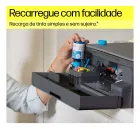 Mão recarrega tinta azul na impressora HP Smart Tank.