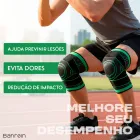 Homem agachando com joelheiras de compressão pretas e verdes em pista