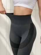 Calça legging cinza escura de cintura alta com textura e listras pretas.