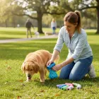 Mulher com golden retriever usando sacos de lixo cocô pet azuis e rolos coloridos na grama