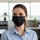 Mulher usando máscara Medix preta descartável com logo, camisa azul