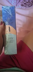 Mão segurando caixa de Body Splash Natura Tododia Todanoite azul e pêssego com plástico.