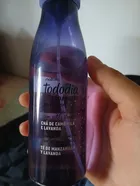 Mão segurando frasco roxo de Natura Tododia Todanoite Body Splash