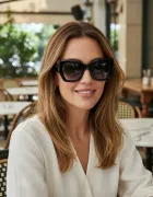 Mulher sorrindo usando óculos de sol Tommy Hilfiger preto com lentes degradê.