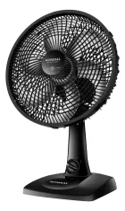 Ventilador de mesa preto com hélice de 6 pás e folhas verdes voando.