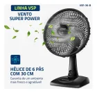 Ventilador de mesa preto com hélice de 6 pás e folhas verdes voando.