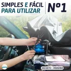 Mãos instalando quebra sol prateado tipo guarda-chuva no para-brisa do carro