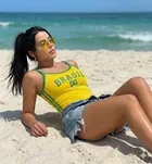 Regata Feminina Cropped amarela Brasil com listras verdes, mulher na praia.