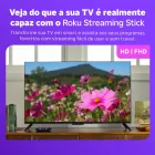 Roku Streaming Stick conectado a TV preta exibindo flores coloridas e controle remoto.